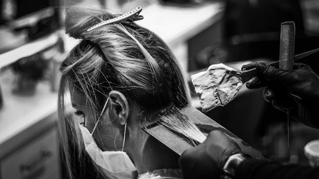 Monochrome image of a woman getting her hair colored in a salon.
